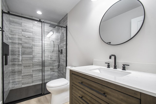 bathroom featuring toilet, wood-type flooring, an enclosed shower, and vanity