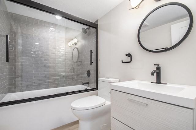 full bathroom featuring toilet, vanity, and shower / bath combination with glass door