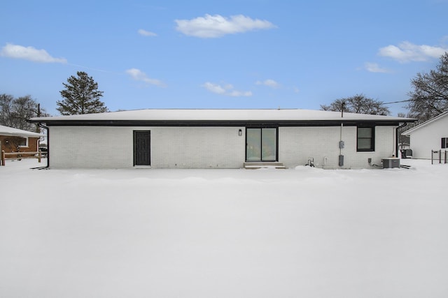 snow covered house featuring central AC