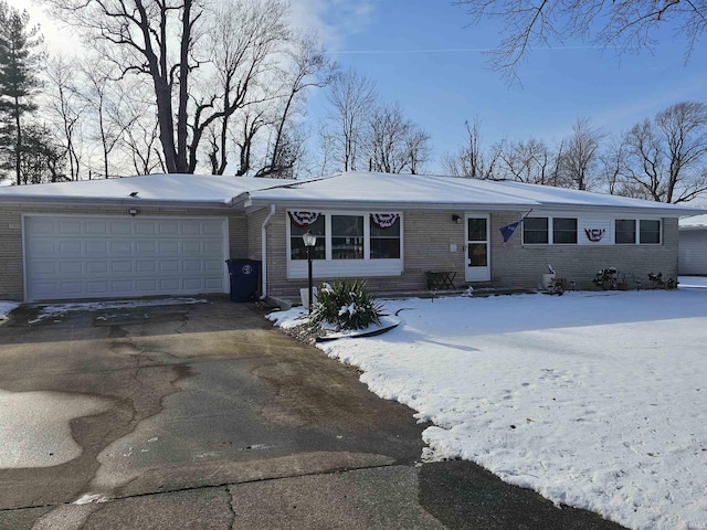ranch-style house with a garage, brick siding, entry steps, and driveway