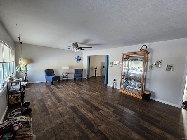 unfurnished room with a textured ceiling, dark wood-type flooring, and ceiling fan