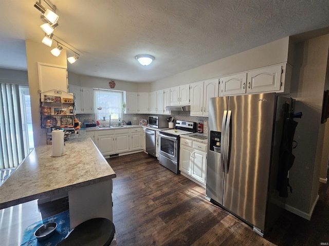 kitchen with white cabinets, stainless steel appliances, dark hardwood / wood-style floors, and tasteful backsplash