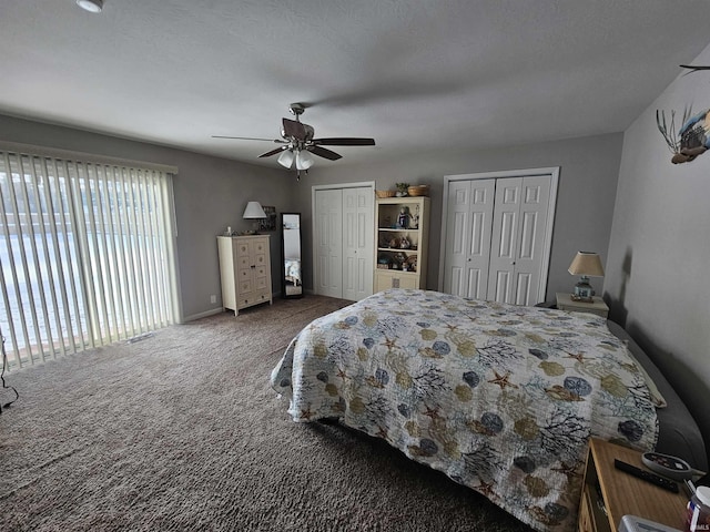 carpeted bedroom featuring ceiling fan and multiple closets