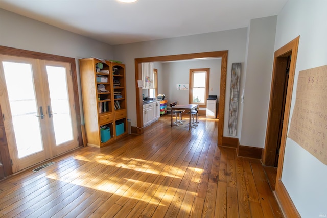 interior space with french doors, hardwood / wood-style flooring, and a healthy amount of sunlight