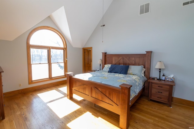 bedroom with high vaulted ceiling and light hardwood / wood-style flooring