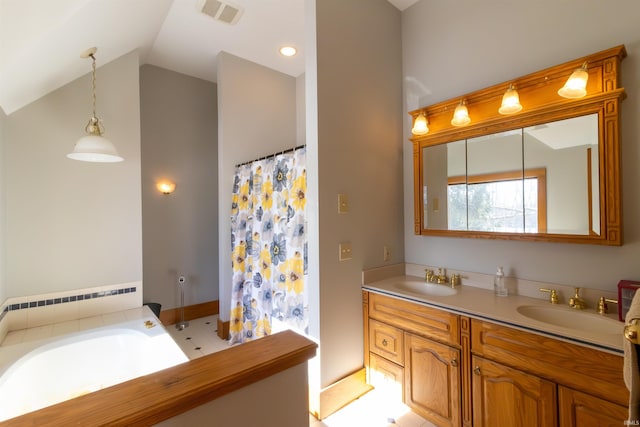 bathroom with vanity, vaulted ceiling, and a tub