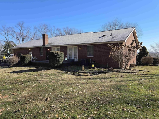 back of property featuring french doors and a lawn