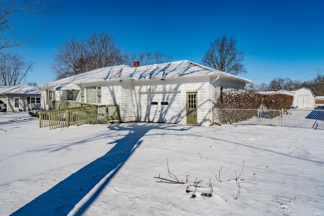 snow covered property featuring a garage