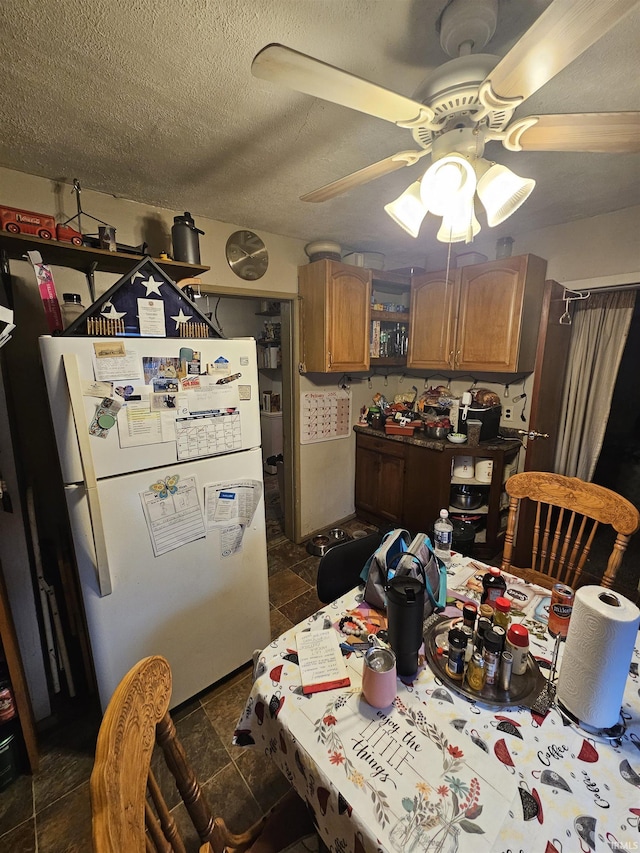 dining area featuring ceiling fan and a textured ceiling