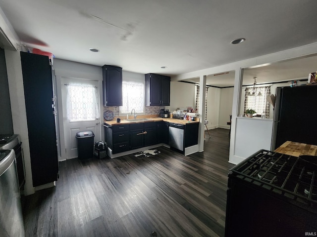 kitchen with sink, black appliances, dark wood-type flooring, and backsplash