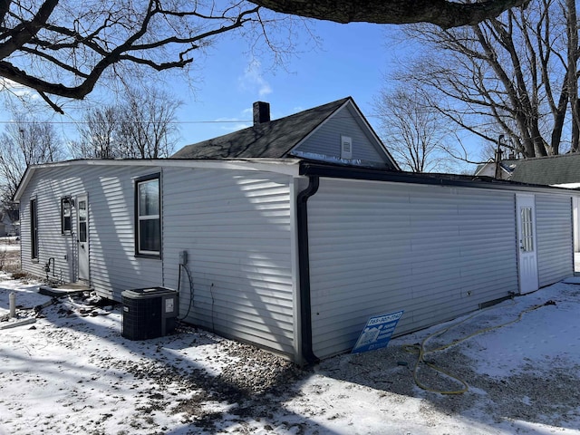 view of snowy exterior with central AC unit