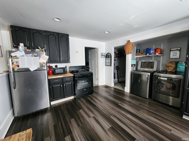 kitchen with washer / dryer, black appliances, and dark hardwood / wood-style flooring