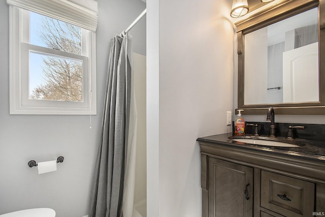 bathroom with toilet, vanity, and curtained shower