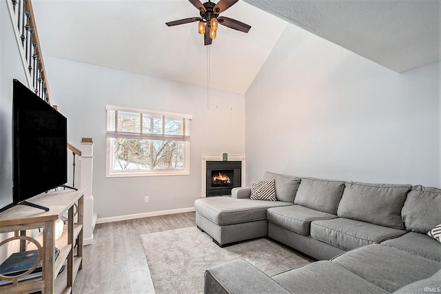 living room featuring high vaulted ceiling, light hardwood / wood-style flooring, and ceiling fan