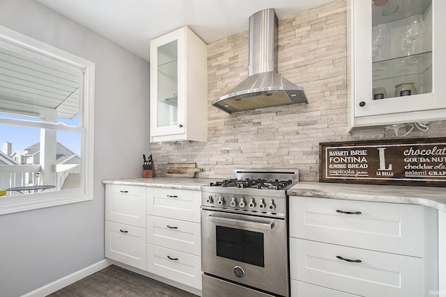 kitchen with white cabinetry, wall chimney range hood, tasteful backsplash, and high end stove