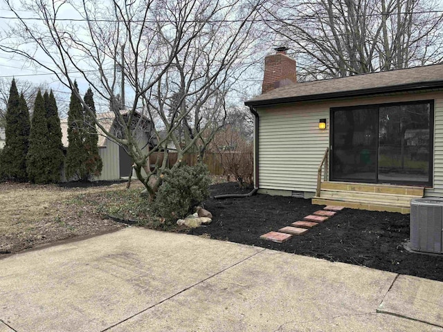 view of yard with an outbuilding, cooling unit, and a patio area