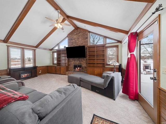 living room with light colored carpet, a brick fireplace, a wainscoted wall, and plenty of natural light