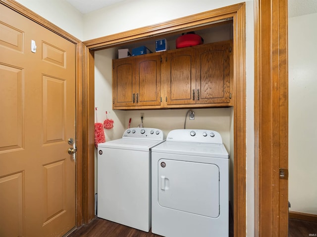 laundry room featuring dark wood finished floors, cabinet space, and washer and dryer