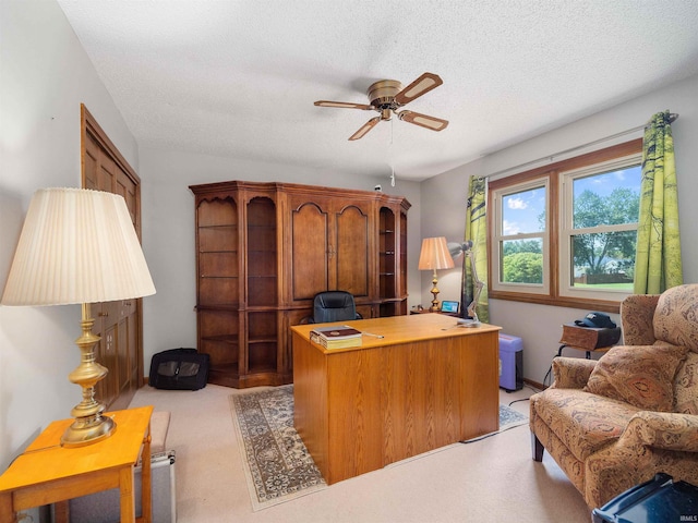 office area with a ceiling fan, light colored carpet, and a textured ceiling