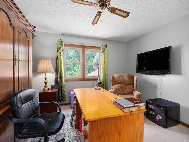 home office featuring a ceiling fan, light colored carpet, a textured ceiling, and baseboards