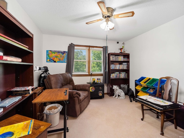 office area featuring a ceiling fan, light colored carpet, and a textured ceiling