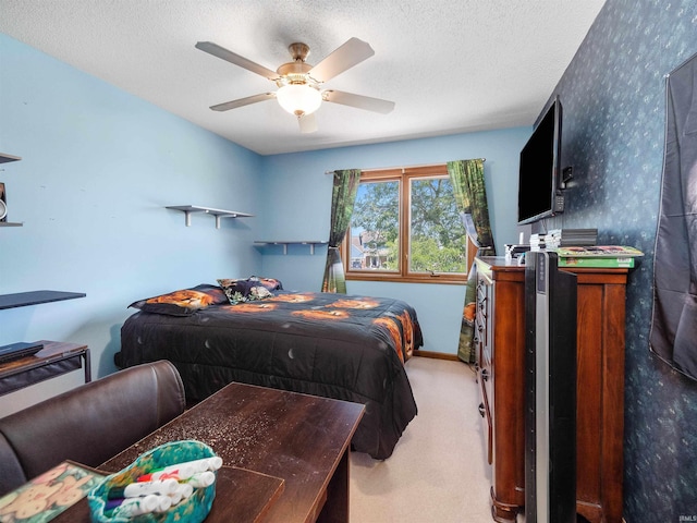 bedroom featuring ceiling fan, a textured ceiling, light carpet, baseboards, and wallpapered walls