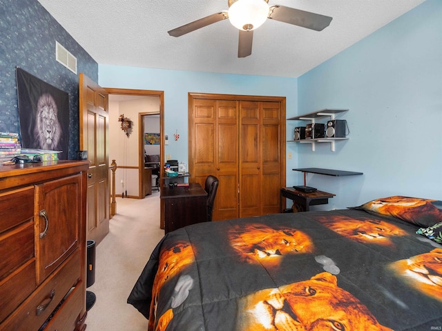 bedroom featuring light carpet, visible vents, a ceiling fan, a textured ceiling, and a closet