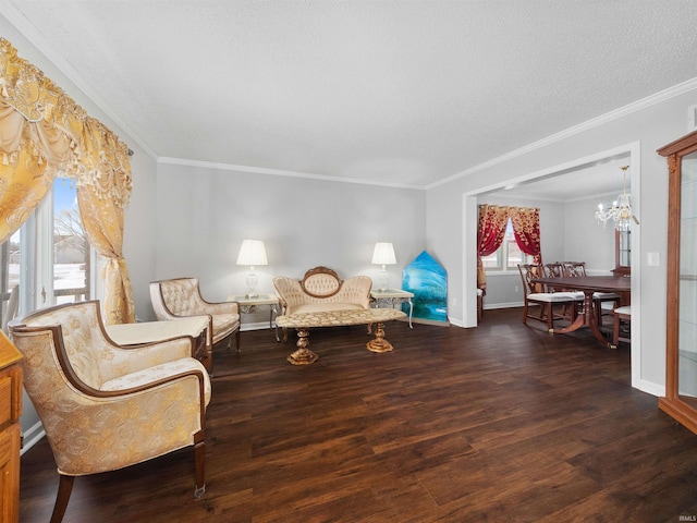 living area featuring baseboards, dark wood-style flooring, crown molding, a textured ceiling, and a chandelier