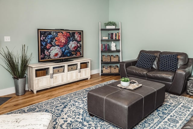 living area featuring baseboards and wood finished floors