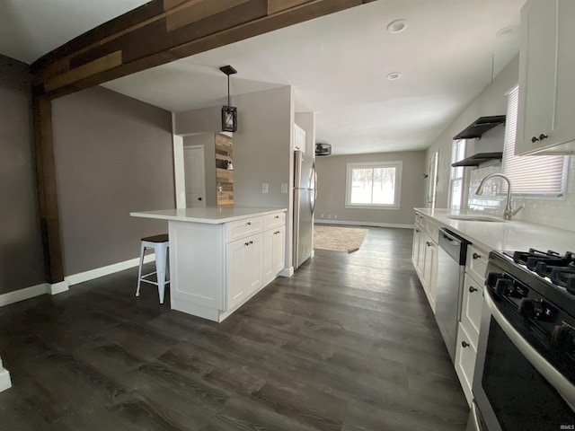 kitchen featuring dark wood-type flooring, tasteful backsplash, appliances with stainless steel finishes, decorative light fixtures, and white cabinetry