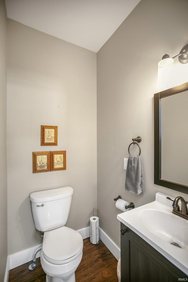 bathroom featuring wood-type flooring, vanity, and toilet