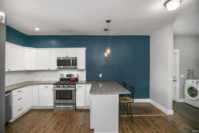 kitchen with stainless steel appliances, washer / dryer, and white cabinetry