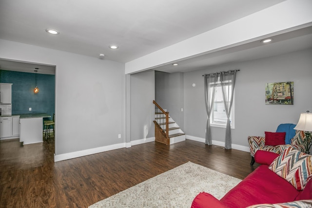 living area with stairs, baseboards, recessed lighting, and dark wood-type flooring