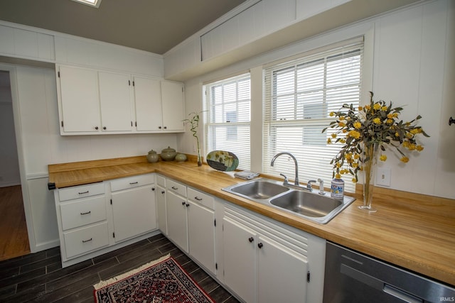 kitchen featuring black dishwasher, white cabinets, wood tiled floor, light countertops, and a sink