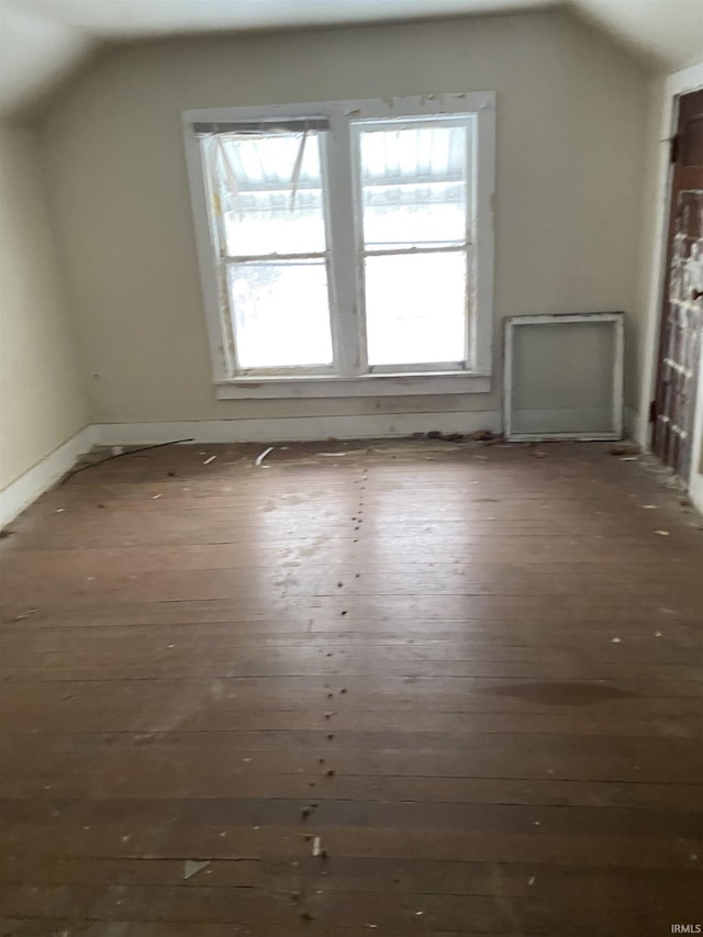 additional living space featuring dark wood finished floors and lofted ceiling