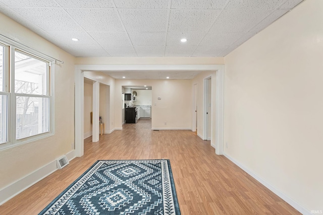 hallway featuring visible vents, baseboards, recessed lighting, and wood finished floors