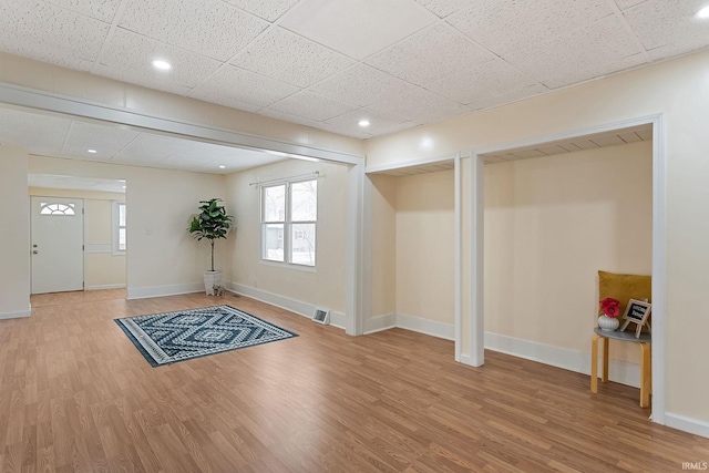 entrance foyer with wood finished floors, baseboards, visible vents, recessed lighting, and a paneled ceiling