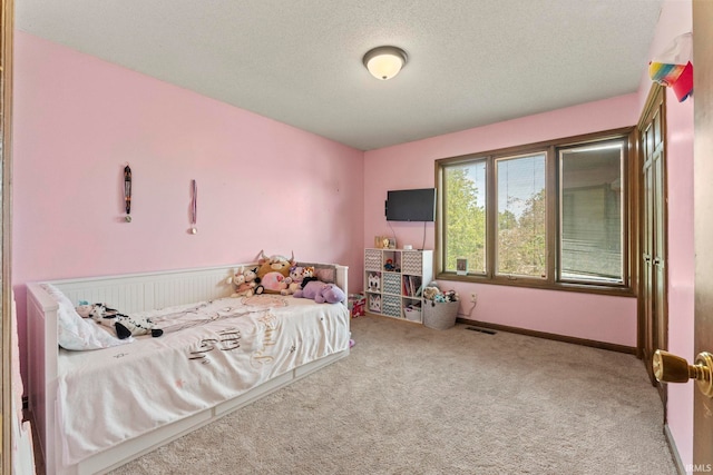 carpeted bedroom featuring visible vents, baseboards, and a textured ceiling