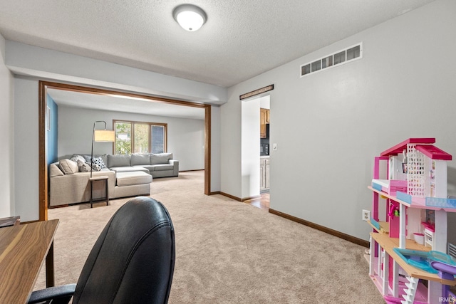 interior space featuring visible vents, baseboards, a textured ceiling, and light colored carpet