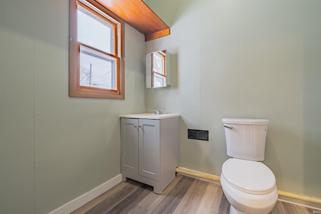 bathroom featuring baseboards, vanity, toilet, and wood finished floors