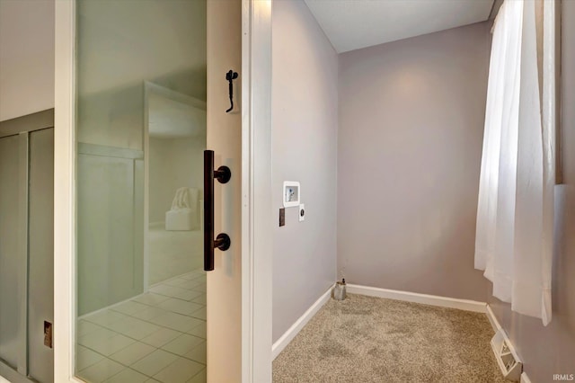 hallway with light carpet, light tile patterned floors, visible vents, and baseboards