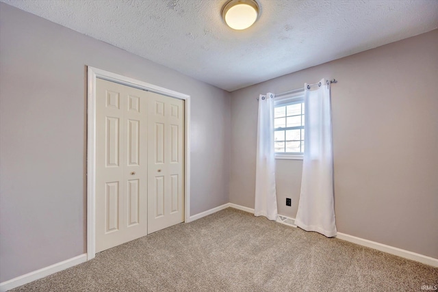 unfurnished bedroom featuring baseboards, a closet, and light colored carpet