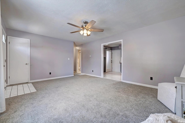 interior space with light colored carpet, a textured ceiling, and baseboards