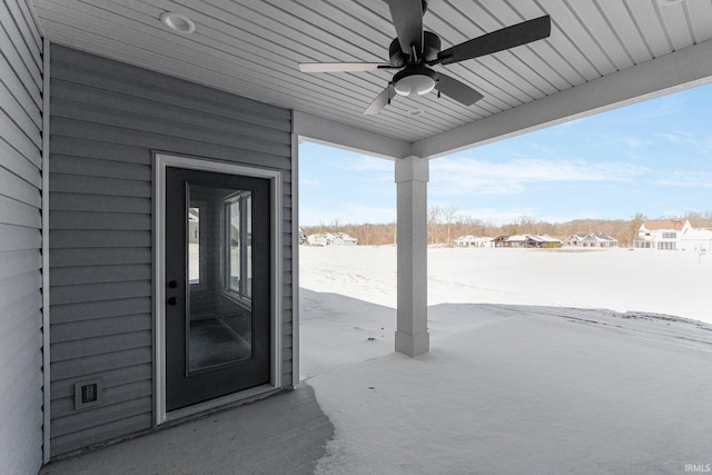 snow covered property entrance featuring a ceiling fan