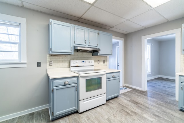 kitchen with tasteful backsplash, light countertops, electric range, and under cabinet range hood