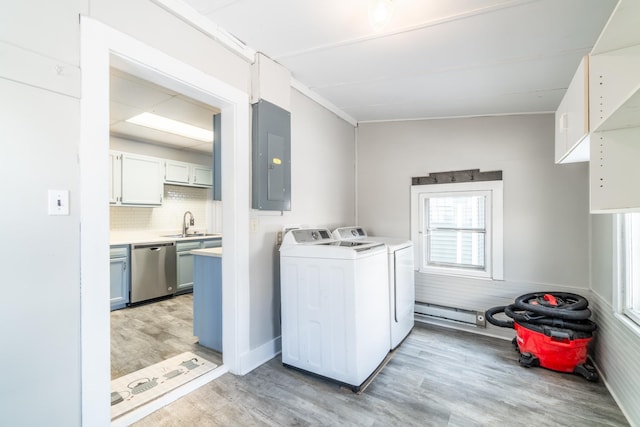 laundry area with washer and dryer, a sink, light wood-type flooring, laundry area, and electric panel