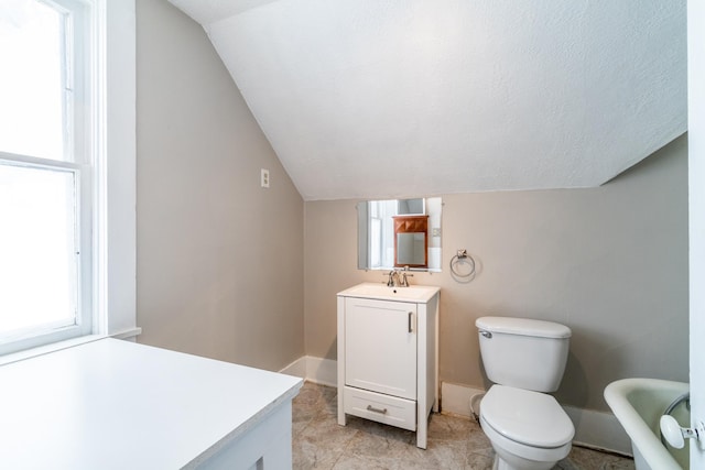 bathroom featuring lofted ceiling, toilet, vanity, a textured ceiling, and baseboards