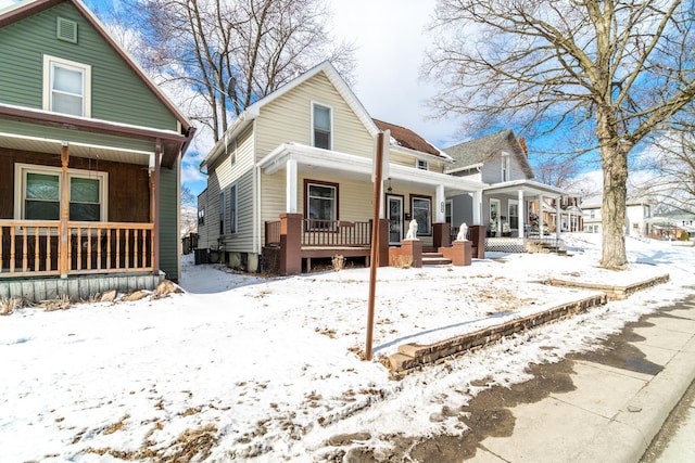 snow covered property with a porch