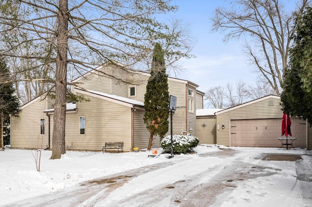 view of snowy exterior with a detached garage