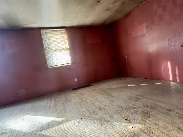 unfurnished room featuring wood finished floors and visible vents